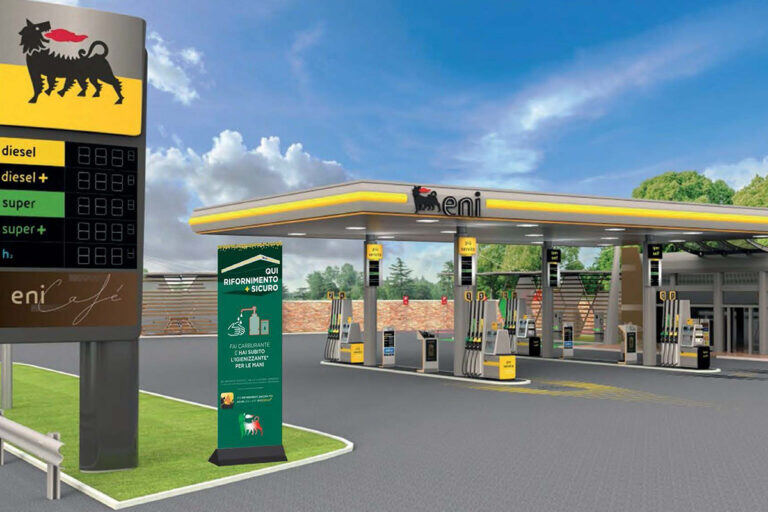 Stazione ENI con pensilina gialla, totem prezzi e aiuole
